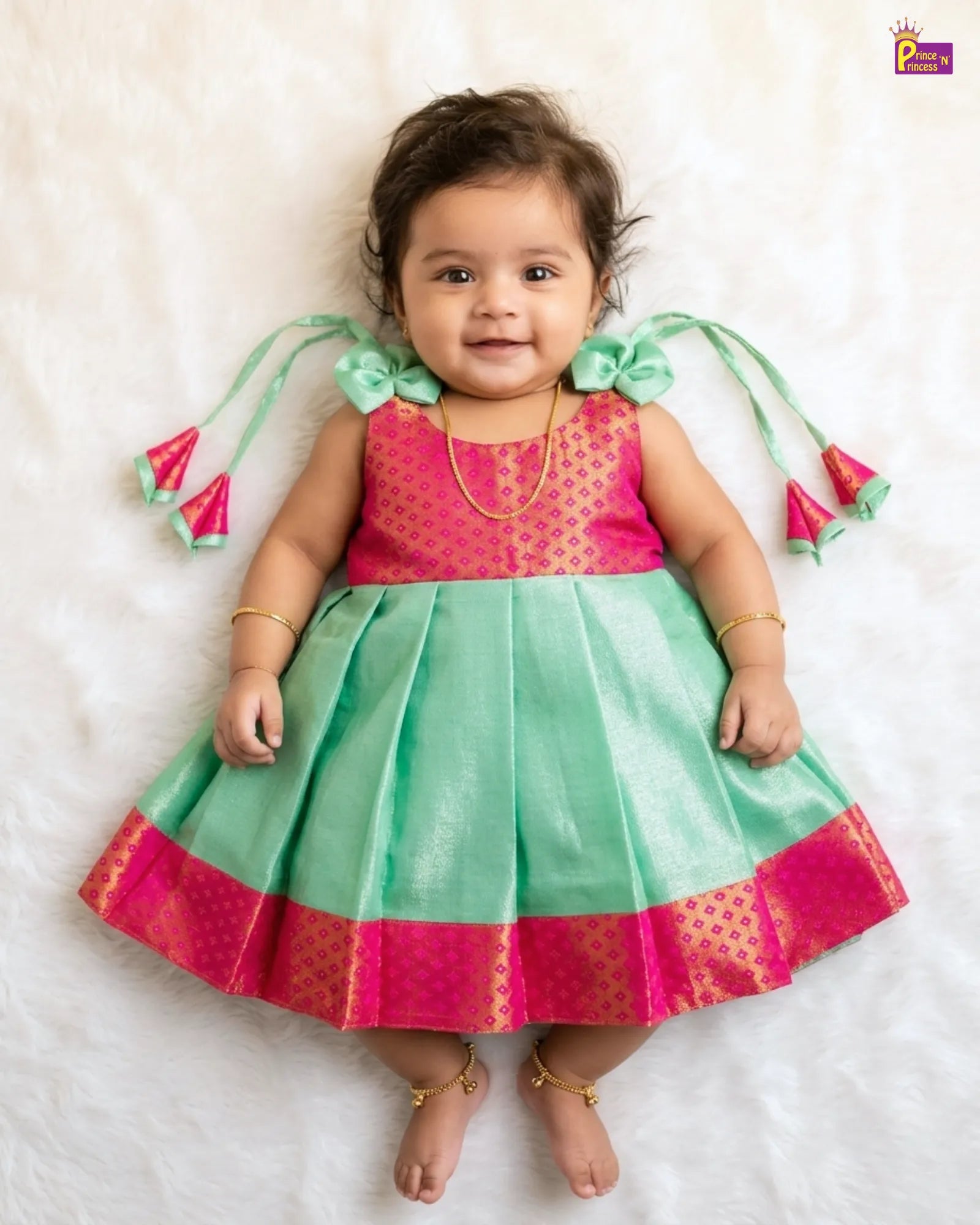 Child wearing a pink and green traditional outfit on a white background