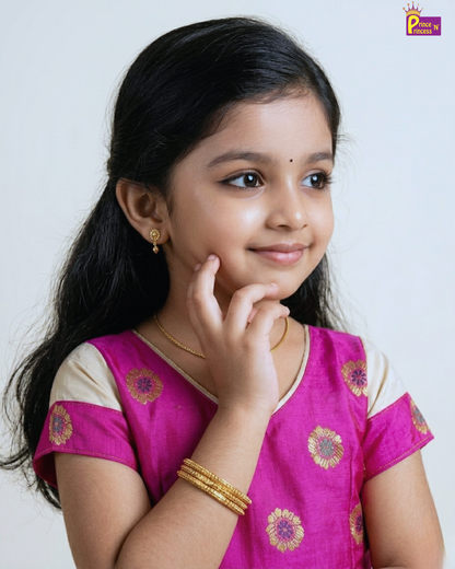 Young girl in a pink traditional outfit with gold jewelry on a white background