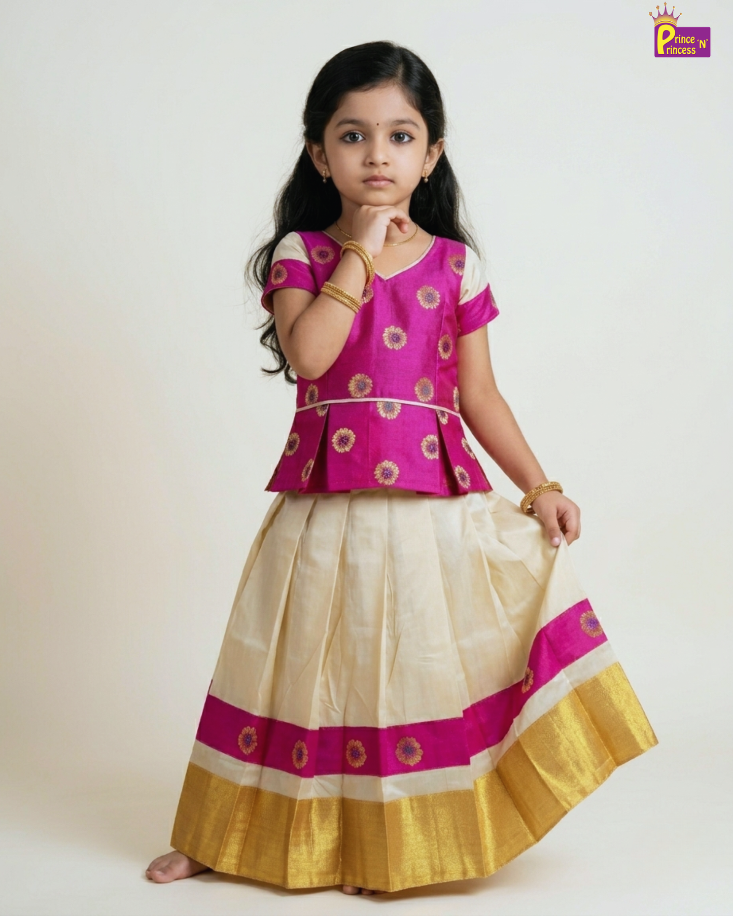 Young girl wearing a traditional outfit with a pink blouse and white and gold skirt on a white background.