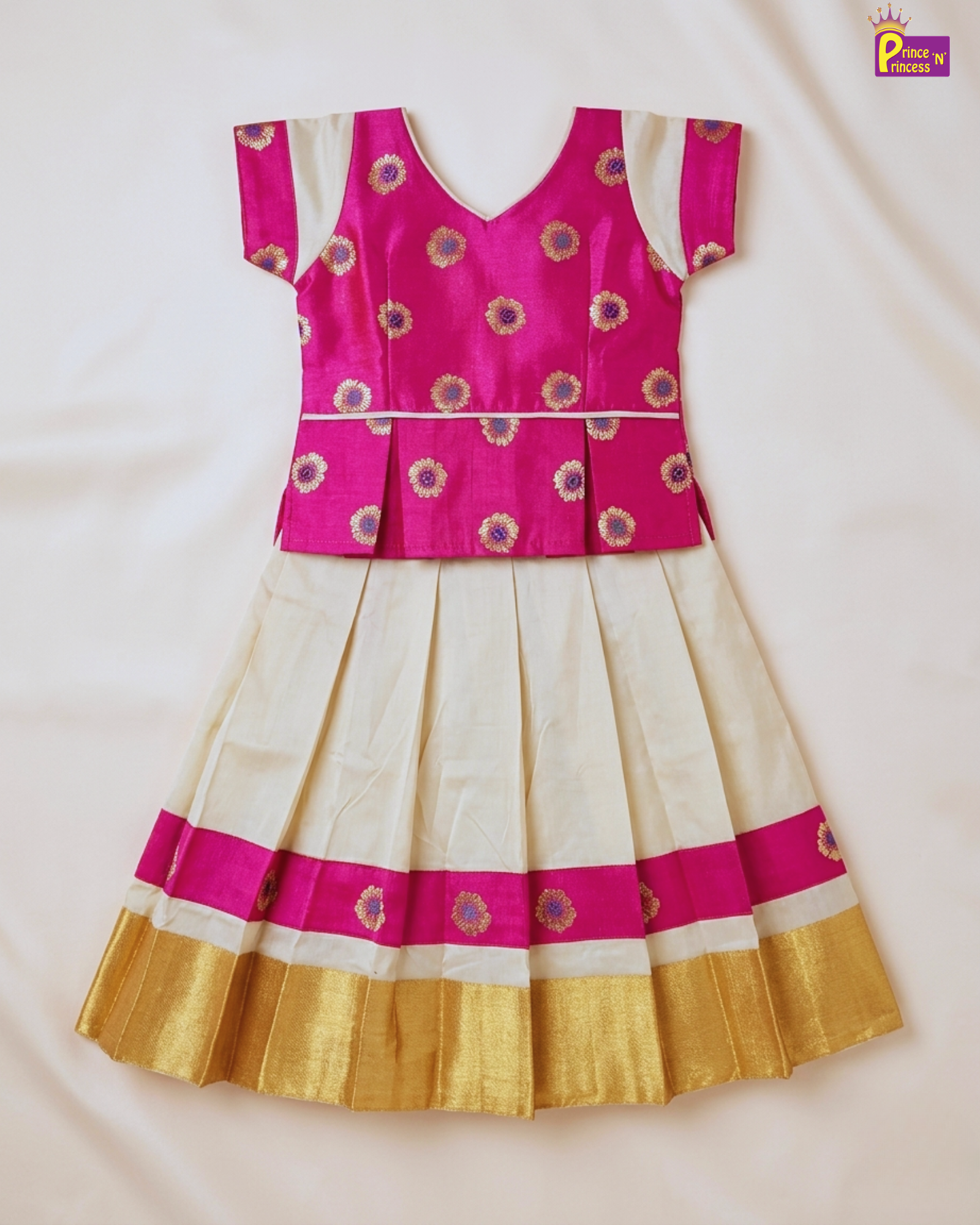 Traditional outfit with pink and gold top and white skirt on a light background