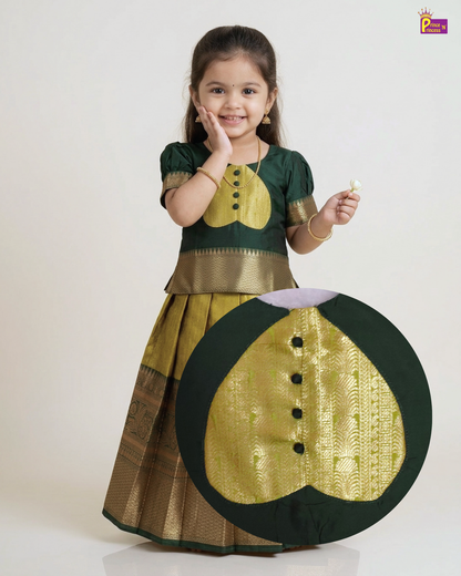A young girl modeling a traditional Indian dress, featuring a dark green top with a gold embroidered chest motif and a matching pleated skirt with gold borders. A large circular inset highlights the detailed gold embroidery on the dress.