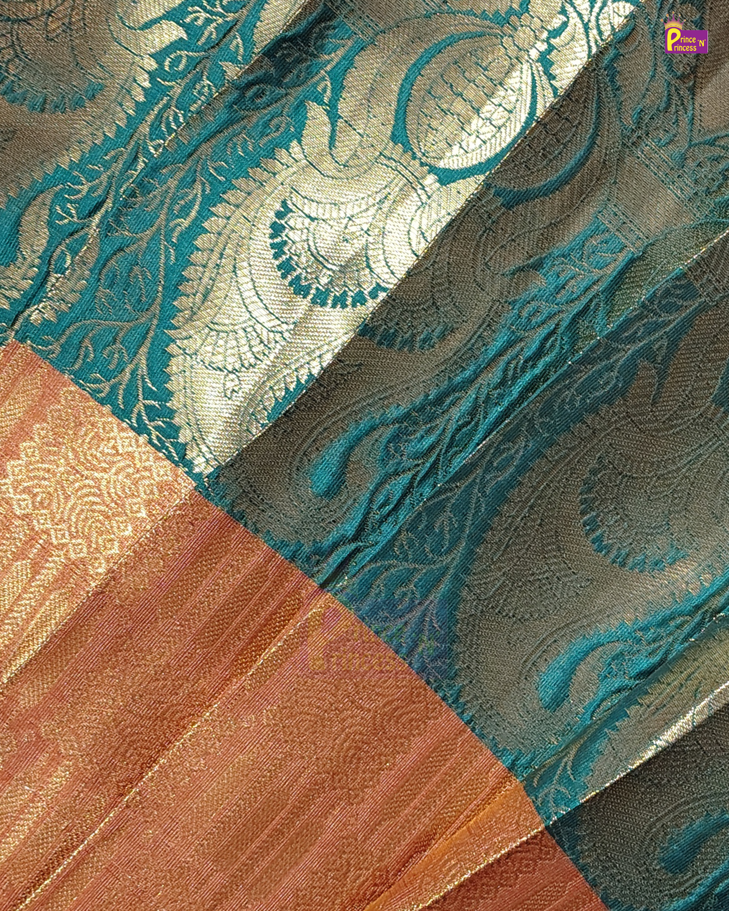 A close-up of a woven fabric with a teal blue and metallic gold paisley pattern, alongside a contrasting peach and gold border section.