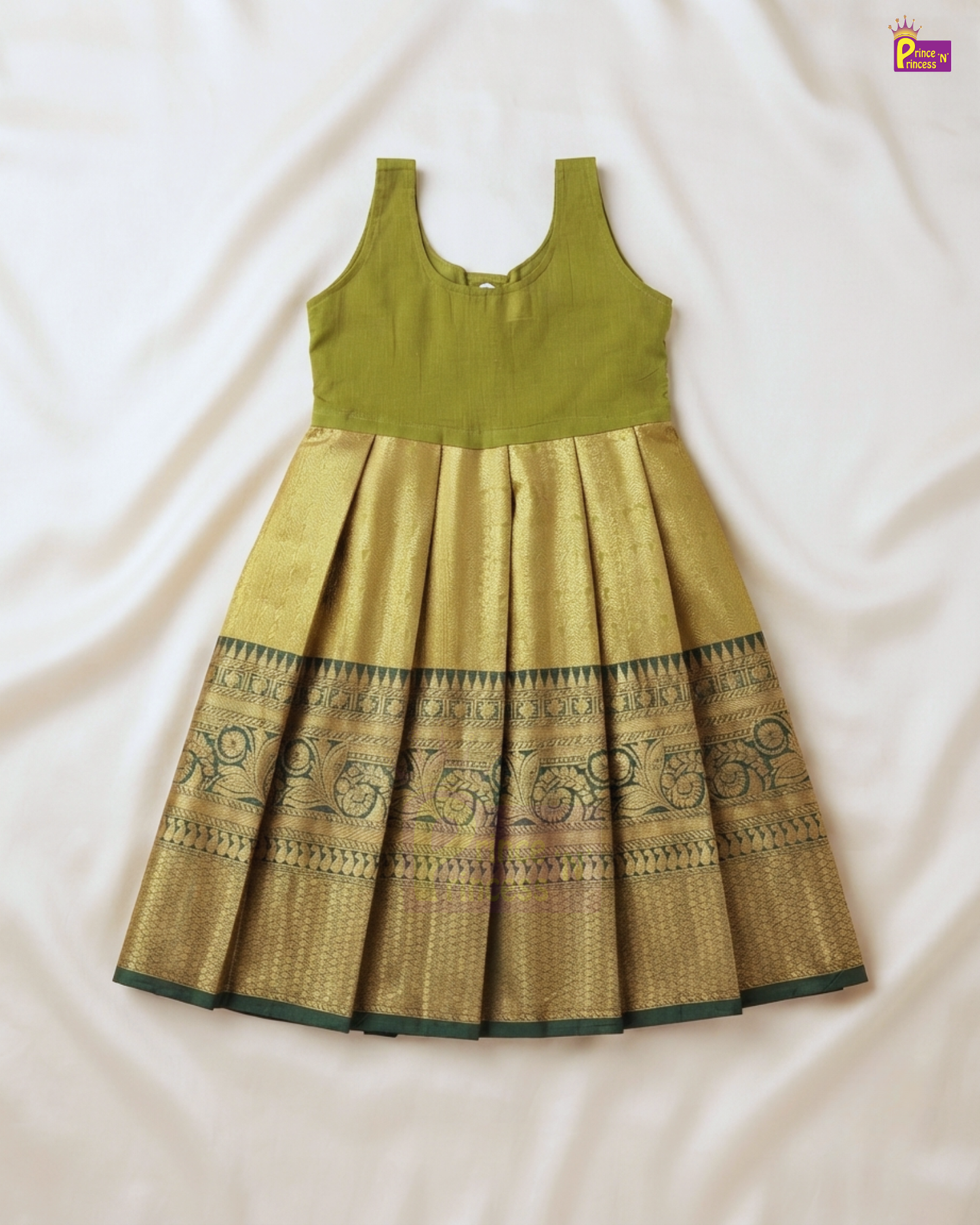 A sleeveless traditional Indian girl's dress laid flat on a white fabric background. The dress features an olive green sleeveless bodice and a pleated gold zari skirt with a dark green border pattern.
