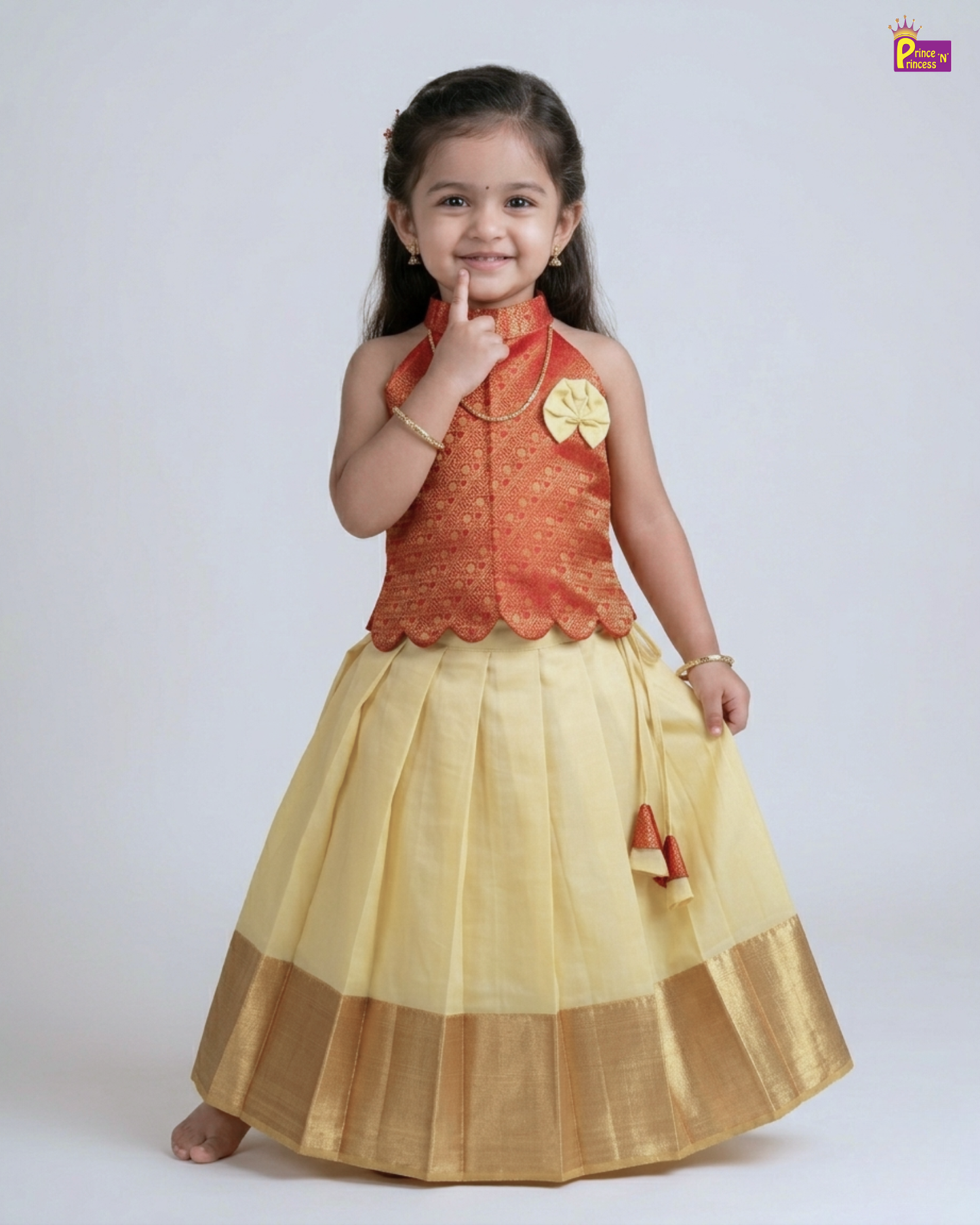 Young girl wearing a traditional outfit with a red top and yellow skirt on a white background