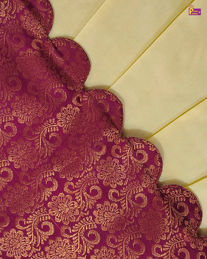 A close-up of a rich magenta-purple brocade fabric with an intricate gold floral and scroll pattern, laid diagonally over a cream-colored background.