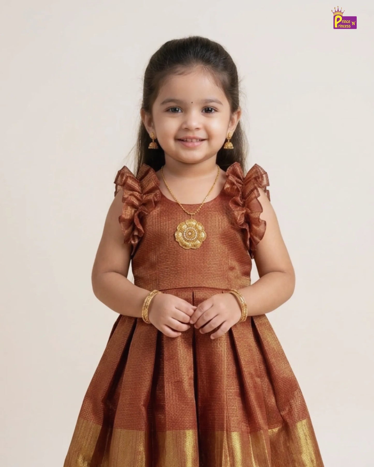 Young girl wearing a traditional brown dress with gold accents on a plain background