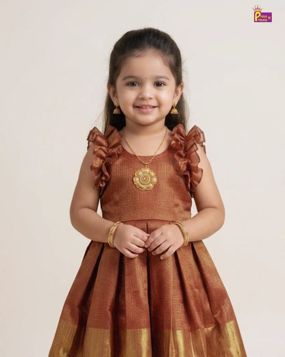 Young girl wearing a traditional brown dress with gold accents on a plain background