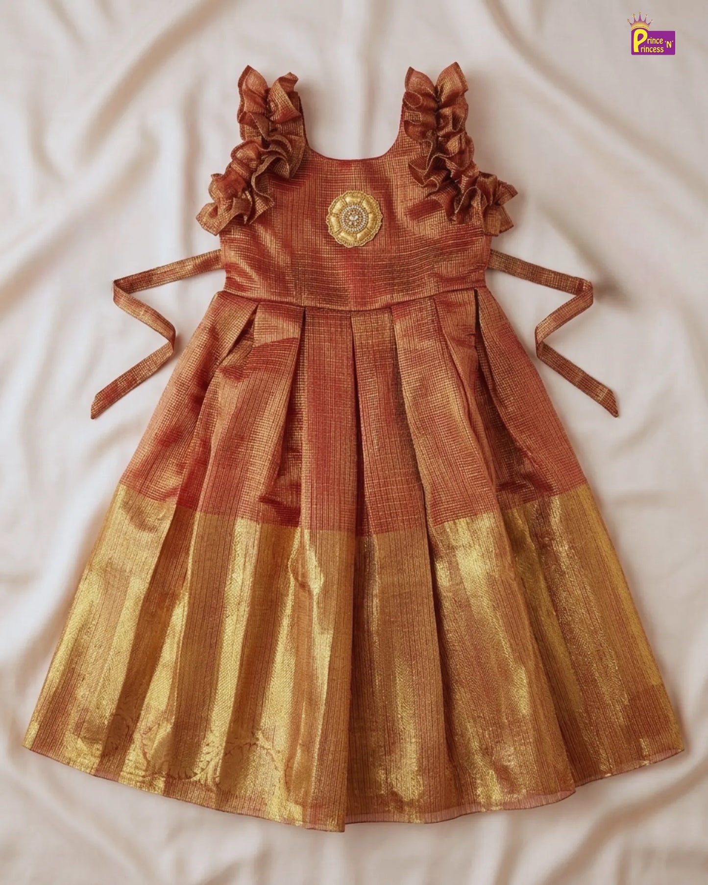 Brown and gold dress with ruffled straps on a white background