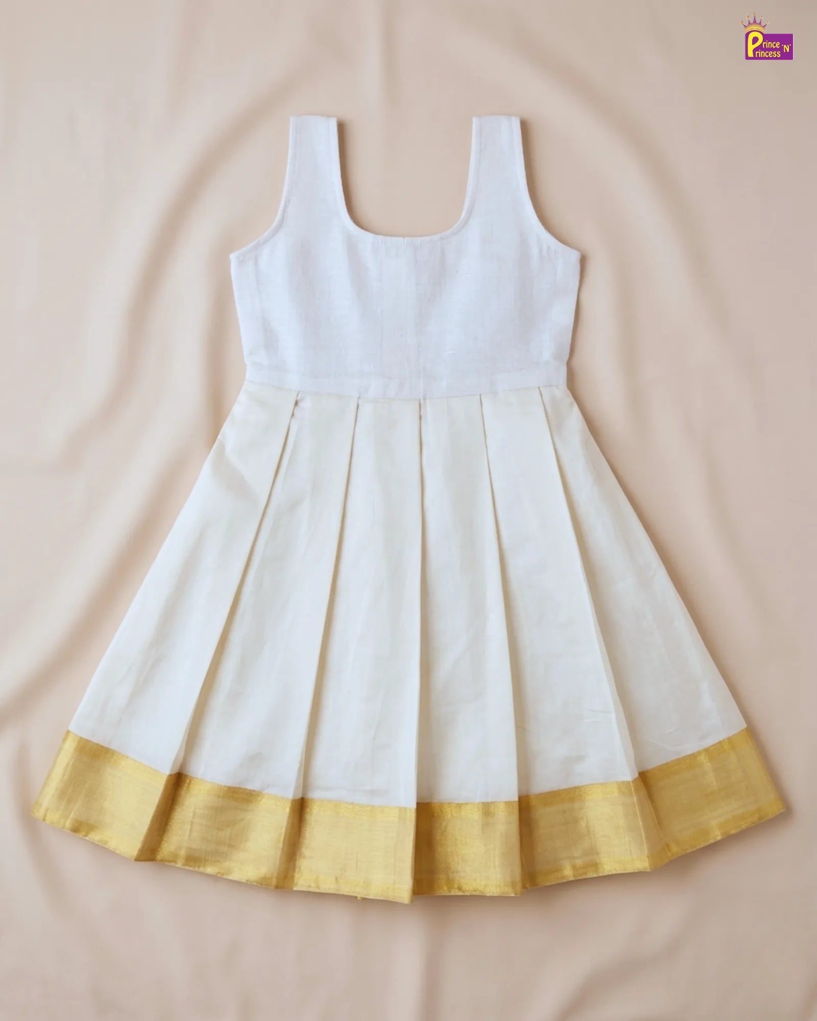 White dress with gold hem on a beige background