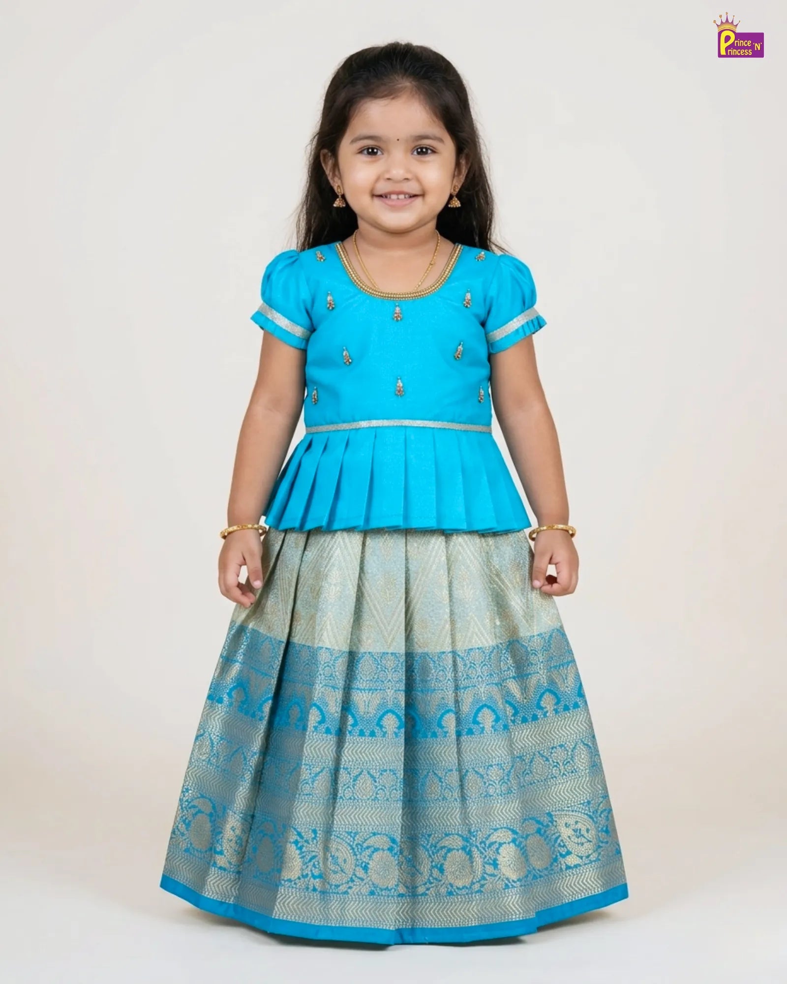 Young girl wearing a blue and gray traditional outfit on a white background