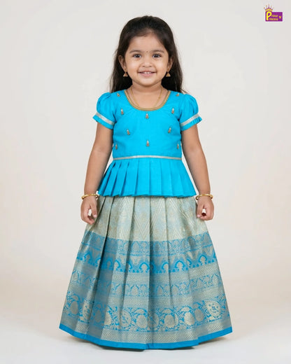Young girl wearing a blue and gray traditional outfit on a white background