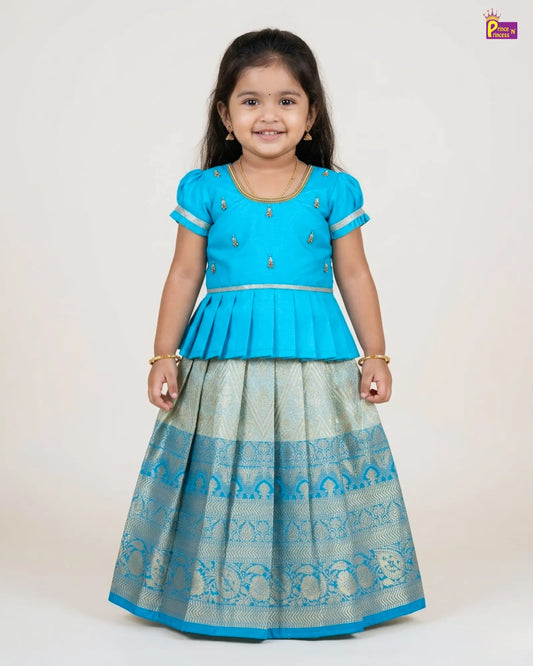 Young girl wearing a blue and gray traditional outfit on a white background
