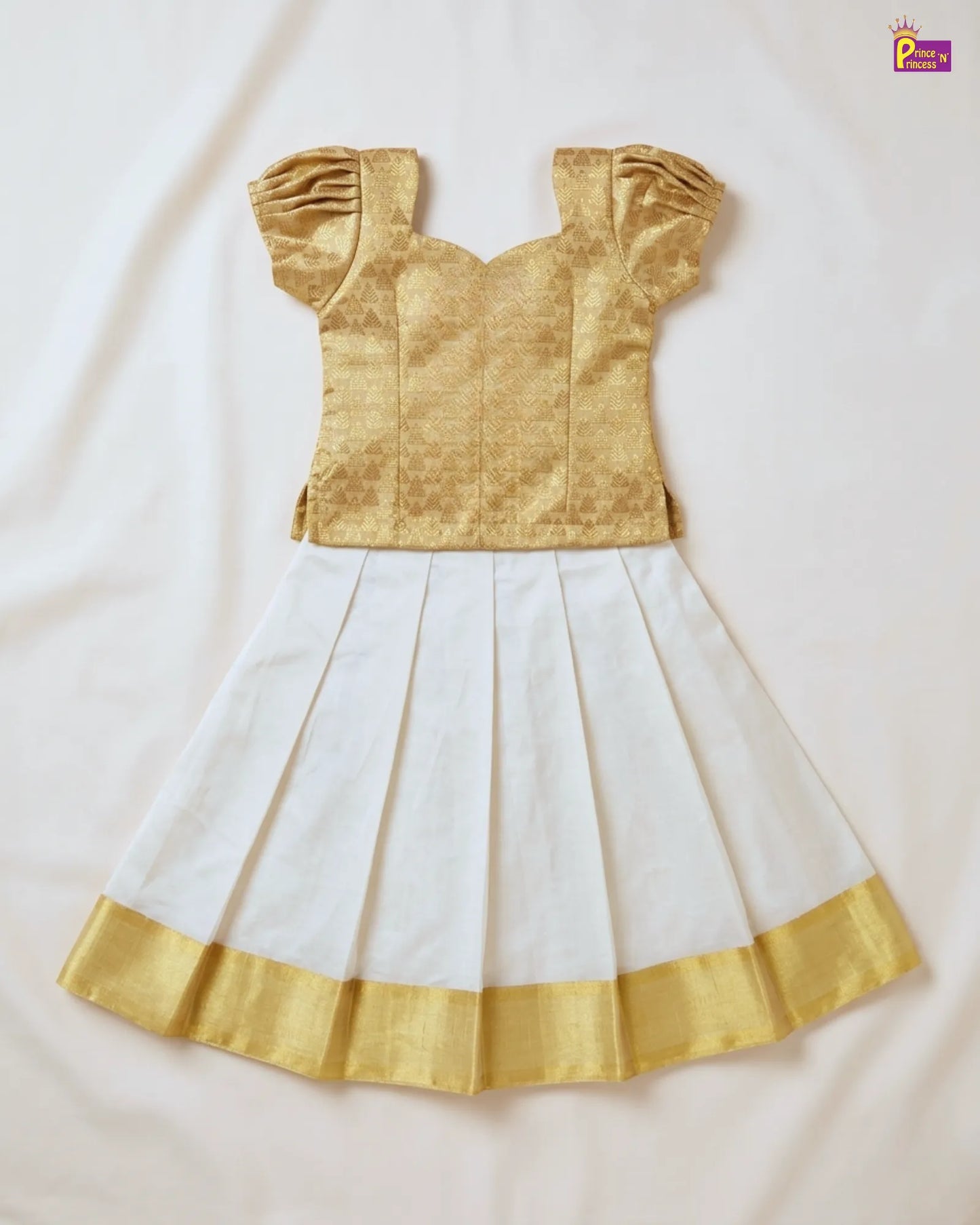 Gold blouse with white saree on a light beige background