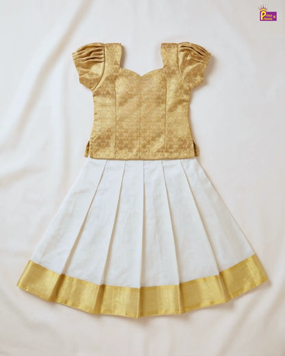 Gold blouse with white saree on a light beige background