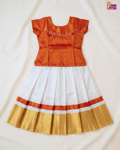 Traditional outfit with orange top, white skirt, and gold border on a light background