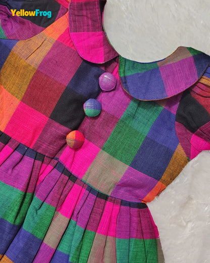 A colorful plaid dress with a large Peter Pan collar and decorative buttons, shown on a white textured background. The brand name 'YellowFrog' is visible in the top left corner.