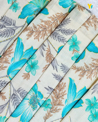 A close-up of pleated fabric with a botanical print featuring bright turquoise blue flowers, teal leaves, and brown foliage on a warm cream background.