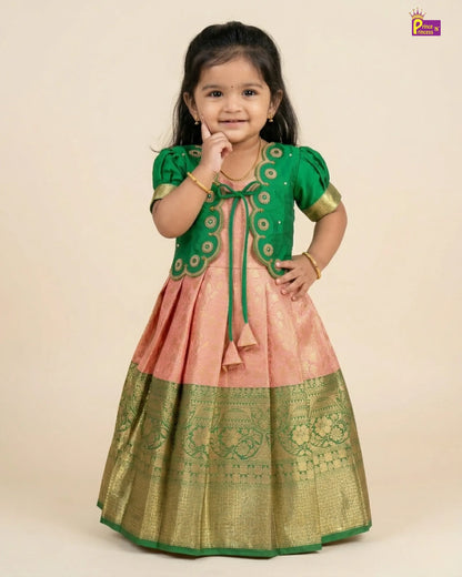 Young girl wearing a green and pink traditional outfit on a beige background
