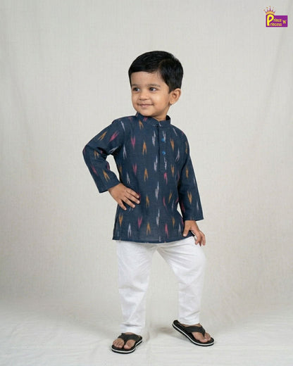 Child wearing a dark blue kurta with colorful patterns and white pants on a light gray background.