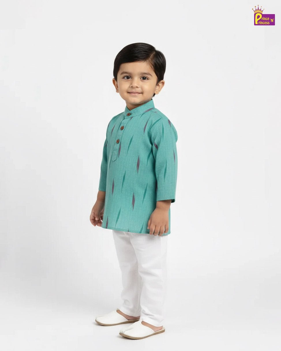 Young boy wearing a green kurta with white pants on a light gray background