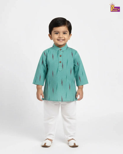 Child wearing a green kurta with white pants on a white background