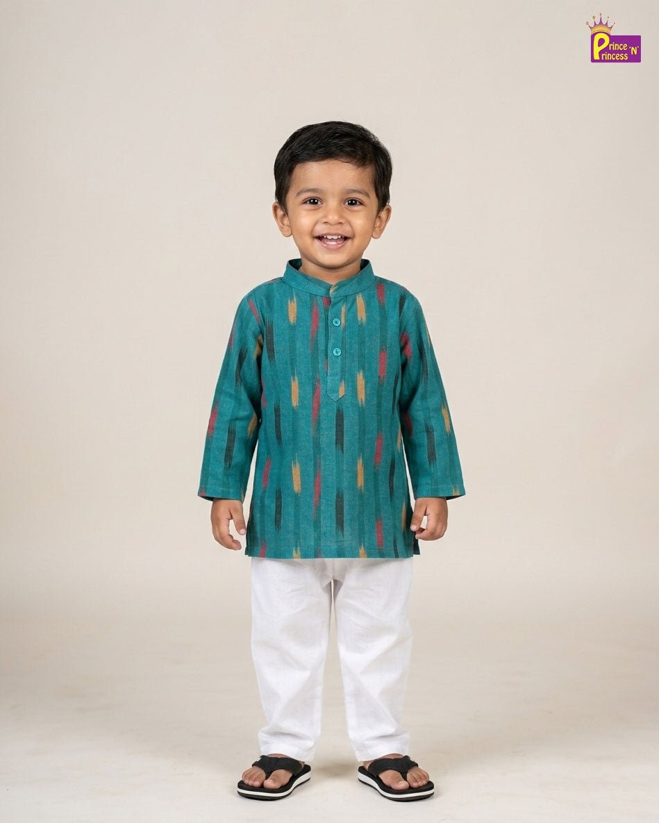 Child wearing a teal kurta with colorful patterns and white pants on a beige background