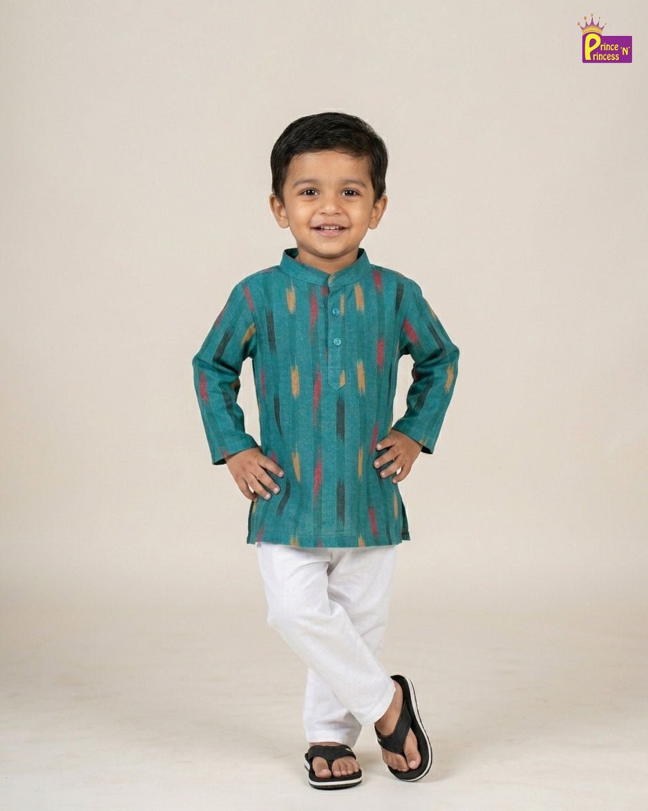 Child wearing a green kurta with white pants on a beige background