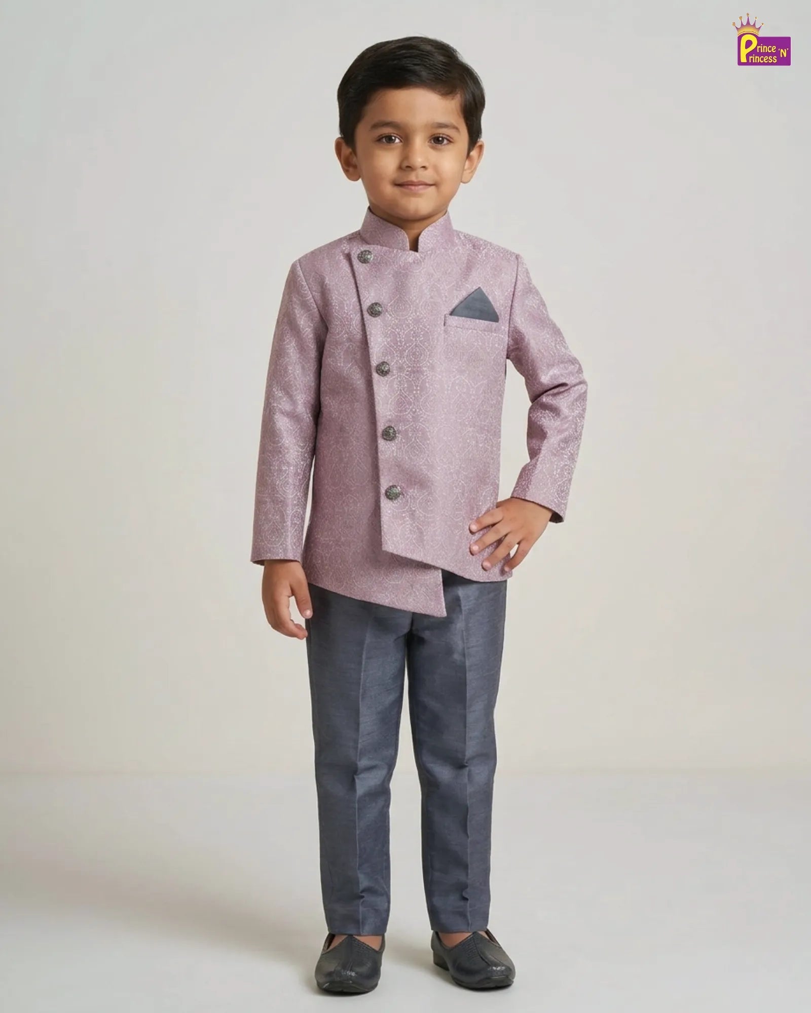 Young boy wearing a pink traditional jacket and gray pants on a white background