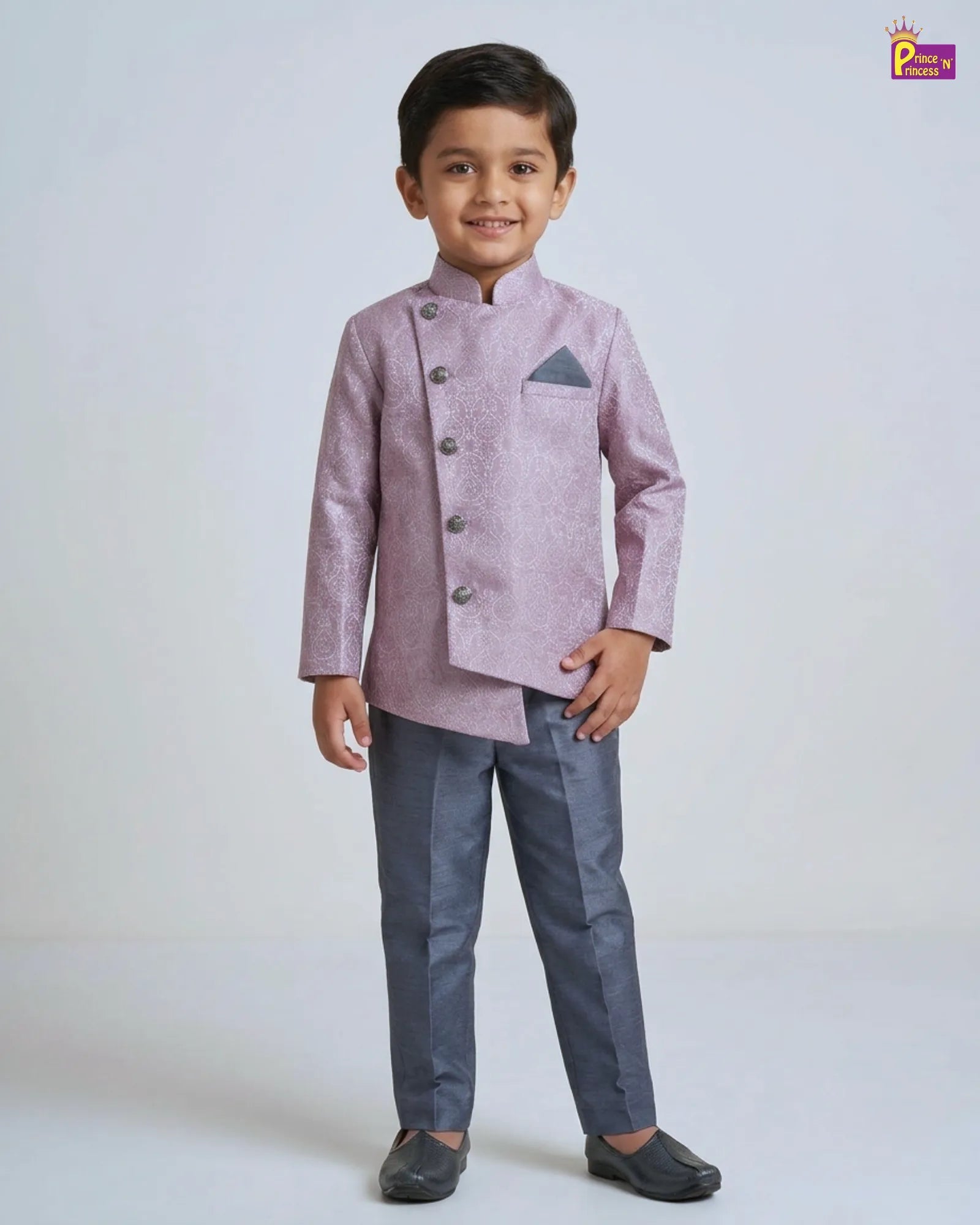 Young boy wearing a pink traditional jacket and gray pants on a white background