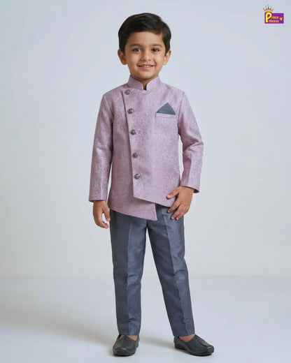 Young boy wearing a pink traditional jacket and gray pants on a white background