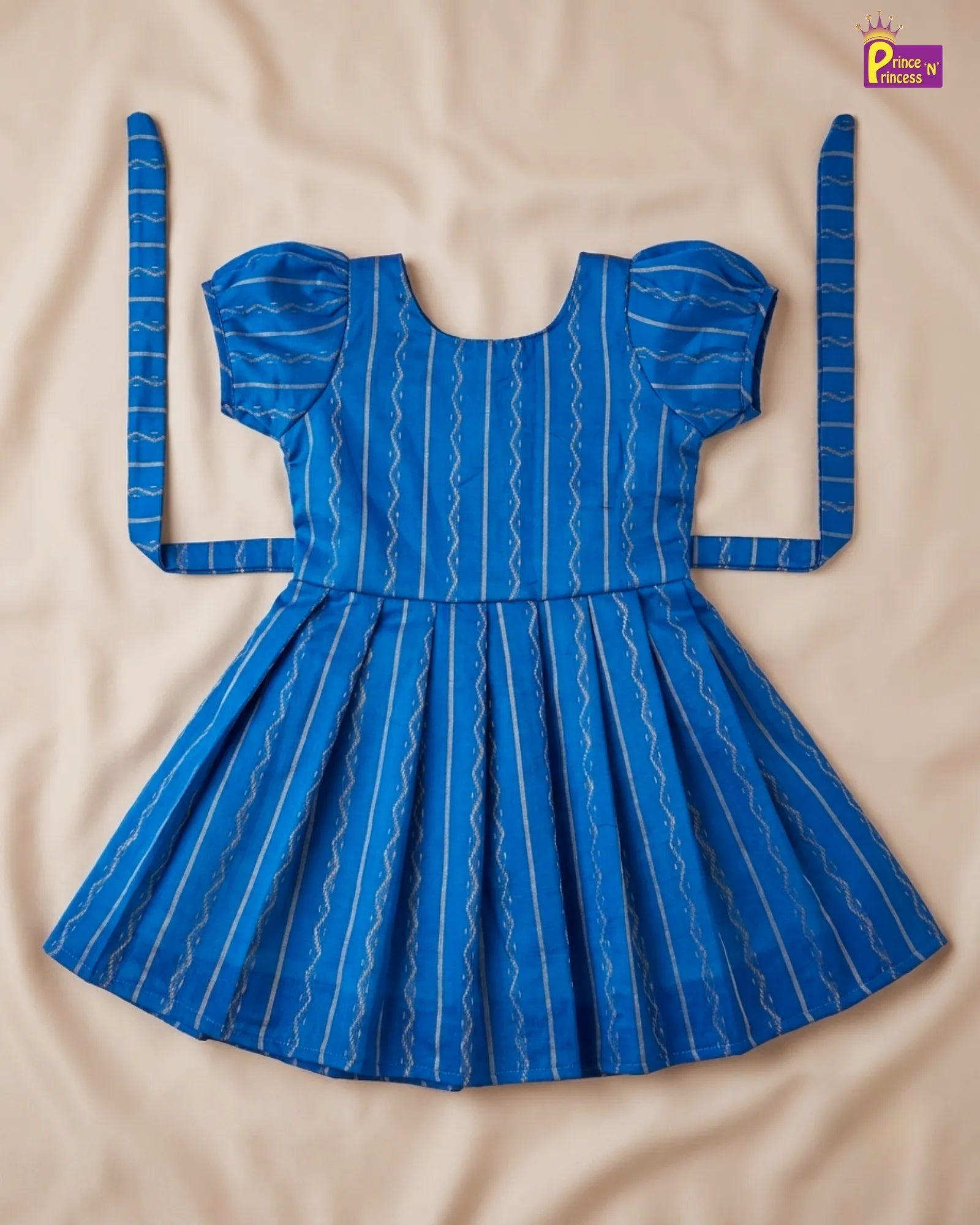 Blue dress with white patterns on a beige background