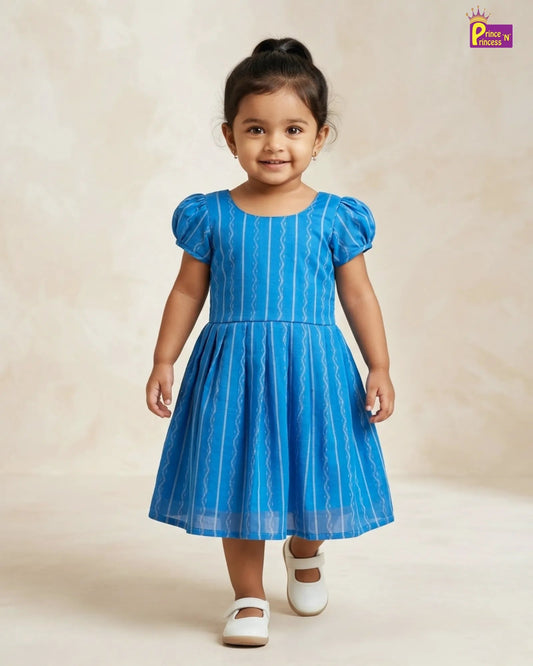 Young girl wearing a blue dress with white stripes on a beige background