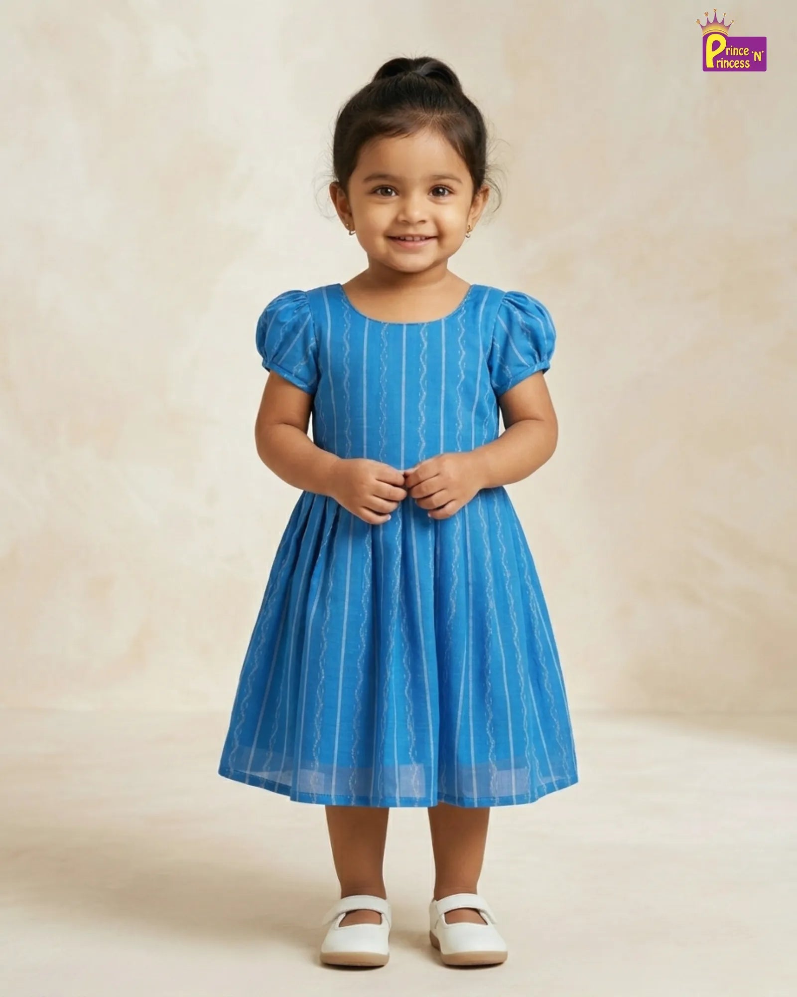 Young girl wearing a blue dress with white stripes on a beige background