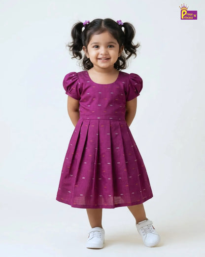 Young girl wearing a purple dress with white polka dots on a white background