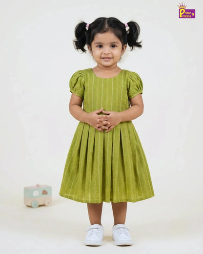 Young girl wearing a green dress with pigtails on a white background