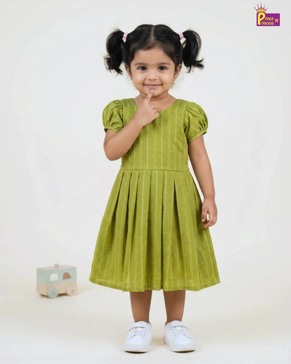Young girl wearing a green dress with pigtails on a white background