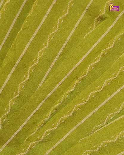 A close-up of a green fabric with diagonal cream-colored stripes and woven zigzag patterns, showing the material texture.
