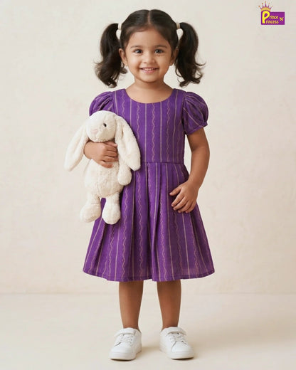 Young girl in a purple dress holding a white stuffed bunny toy on a plain background