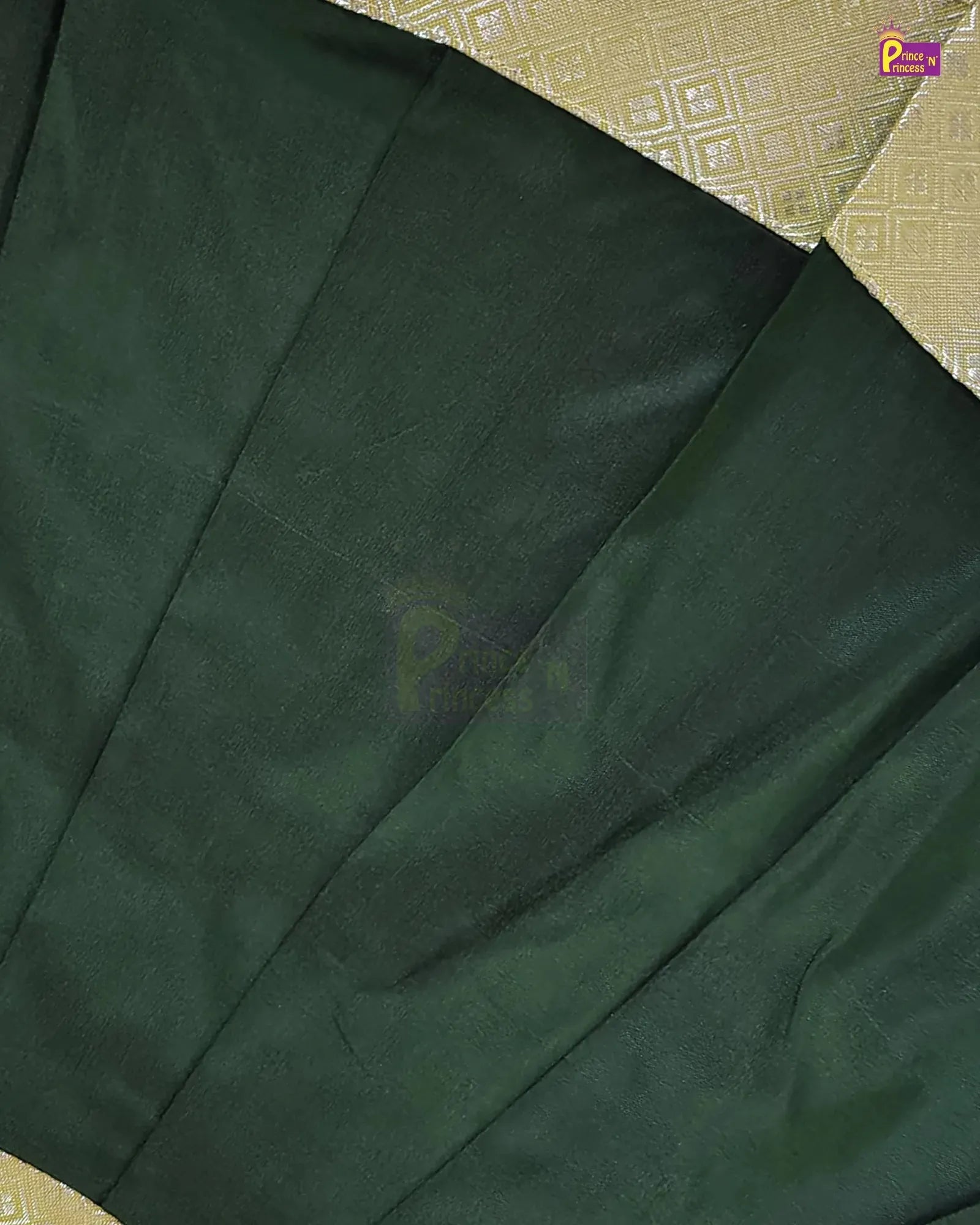 A close-up of dark forest green pleated fabric, likely a sari, laid over a beige patterned textile background. A small 'Pichwai' brand logo is visible in the top right corner.