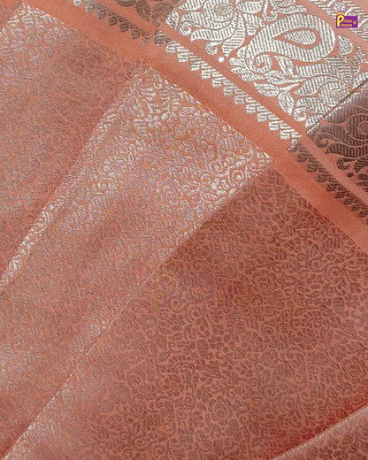 Close-up of peach-colored fabric with an allover tonal floral jacquard pattern and a decorative silver border.